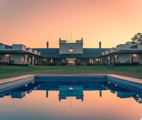 a house with a swimming pool in front of it at Hotel Santa Cristina in Durazno