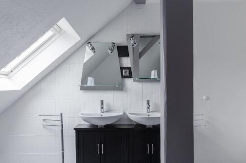 La salle de bains est pourvue de 2 lavabos et d'un miroir. dans l'établissement Gîte spacieux, lumineux et très cosy, à Lautenbach