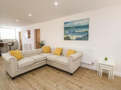 a living room with a white couch and a painting at The Church in Holyhead