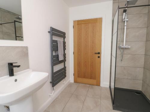 a bathroom with a sink and a shower and a door at The Church in Holyhead