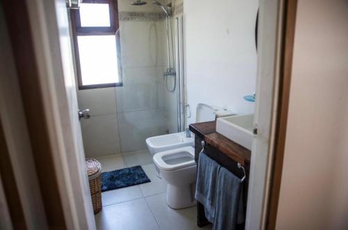 y baño con aseo, lavabo y ducha. en Chacra Los Arándanos en Durazno