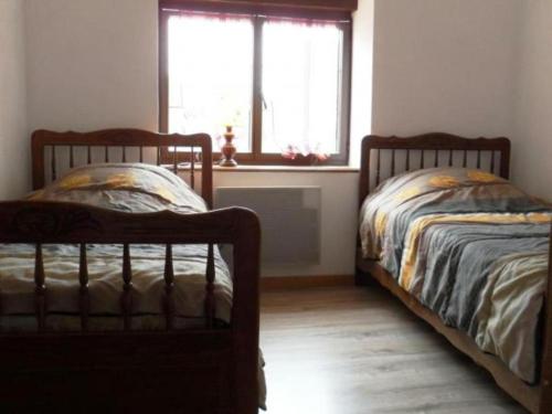 two twin beds in a room with a window at Chambres d hôtes chez Georges in Spoy