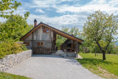 a barn house with a stone wall and trees at MARRYS APARTMENTS in Polica