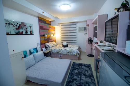 ein kleines Zimmer mit einem Bett und einer Couch in der Unterkunft Cozy Chic Condotel Avida Towers Sucat in Manila