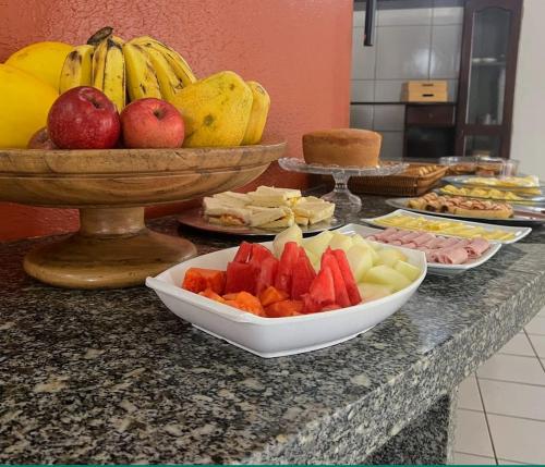 un mostrador con tazones de fruta y platos de comida en SÃO CRISTOVÃO HOTEL, en São Luís