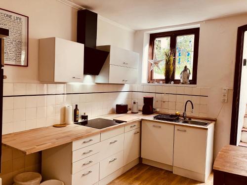 cocina con armarios blancos, fregadero y ventana en Zentrales und ruhiges Apartment im beliebtesten Bremer Viertel, en Bremen