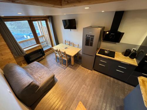 une petite cuisine avec une table et un réfrigérateur dans l'établissement Val Thorens Appartement 8 personnes aux pieds des pistes, à Val Thorens
