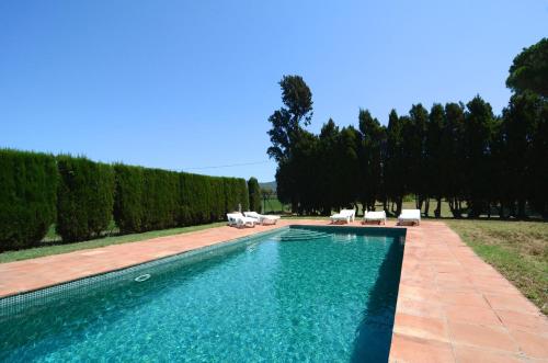 - une piscine dans une cour avec des chaises et des arbres dans l'établissement Villa Mas Dels Noguers, à Torroella de Montgrí