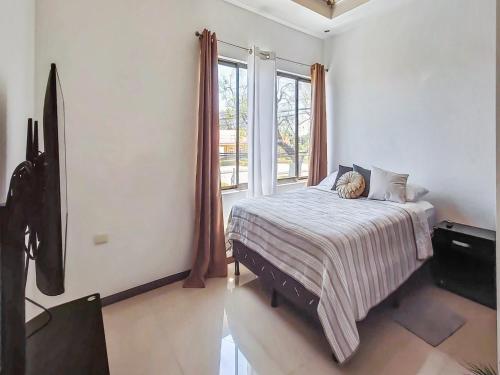 a bedroom with a bed and a large window at Apartment Equipped With Excellent Location in Liberia