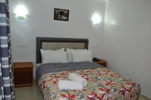 a bedroom with a bed with two towels on it at Hotel La Place in El Jadida