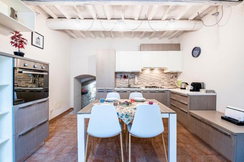 uma cozinha com uma mesa de jantar e cadeiras brancas em "Florence Cave Central Suite" - 5 min To Mandela Forum - 2 Bedrooms - Free Parking em Florença