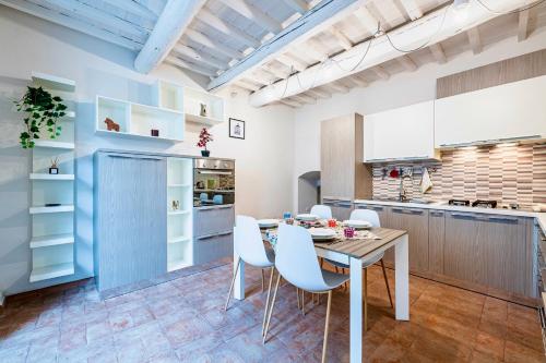 a kitchen with a table and white chairs at "Florence Cave Central Suite" - 5 min To Mandela Forum - 2 Bedrooms - Free Parking in Florence