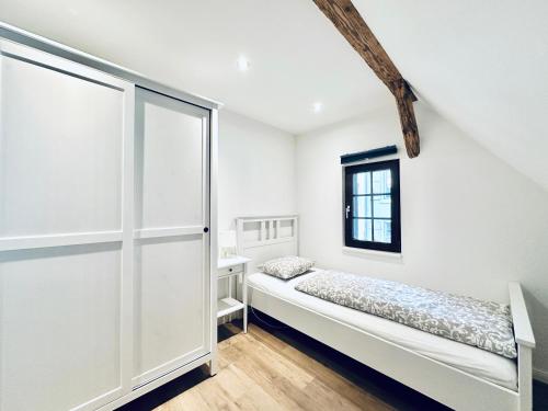 ein weißes Zimmer mit einem Bett und einem Fenster in der Unterkunft Business Apartment ZIMMERzuVERMIETEN in Wangen an der Aare in Wangen an der Aare
