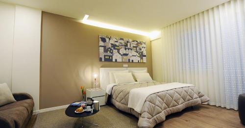 マテーラにあるTerrazza Sui Sassiのベッドとソファ付きのホテルルーム