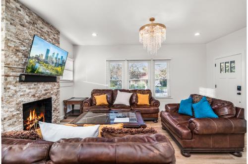 a living room with leather furniture and a fireplace at Bold Bright 4BR3.5FULL BATHS Near Riverwalk Dtown in San Antonio