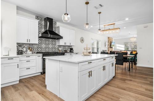 a kitchen with white cabinets and a dining room at Bold Bright 4BR3.5FULL BATHS Near Riverwalk Dtown in San Antonio