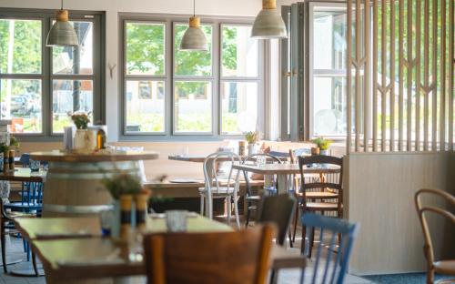 a dining room with tables and chairs and windows at Boutique Hotel Soyka in Špindlerův Mlýn
