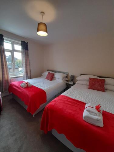 a bedroom with two beds with red sheets at Matipa-Rise Guest House Southampton in Southampton