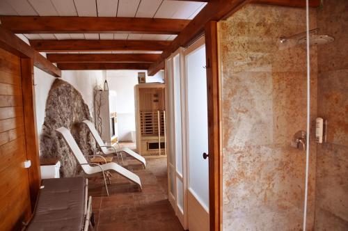 ein Bad mit Dusche und Stühlen in einem Zimmer in der Unterkunft Toncevi Eco Estate in Branik