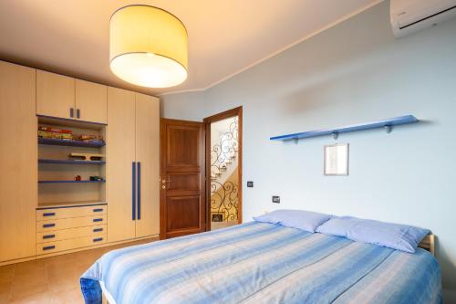 a bedroom with a bed and a yellow light at Villa il Mandorlo by VacaVilla in Passignano sul Trasimeno