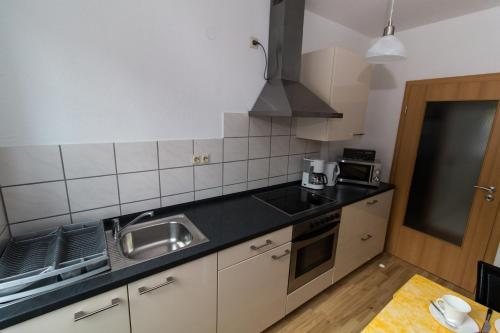 uma cozinha com um lavatório e um fogão em Ferienwohnung Auer em Stockach