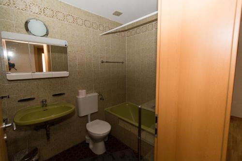 La salle de bains est pourvue d'un lavabo, de toilettes et d'un miroir. dans l'établissement Ferienwohnung Auer, à Stockach