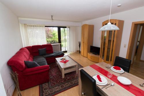 - un salon avec un canapé rouge et une table dans l'établissement Ferienwohnung Auer, à Stockach