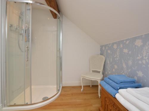 a bathroom with a glass shower and a chair at 1 bed property in Rudyard 75431 in Horton