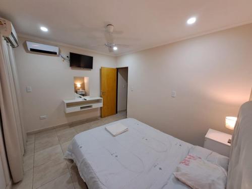 Habitación blanca con cama y TV en ALOJAMIENTO NORTE SGO en Santiago del Estero