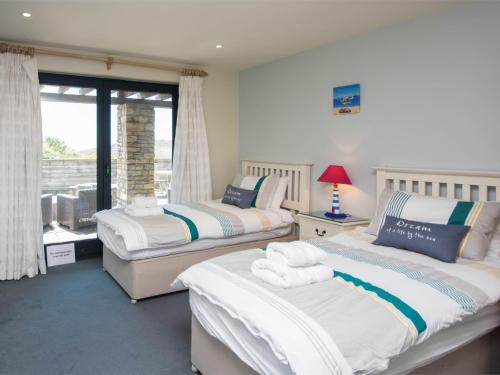a bedroom with two beds and a window at 3 Bed in Worth Matravers DC063 in Worth Matravers