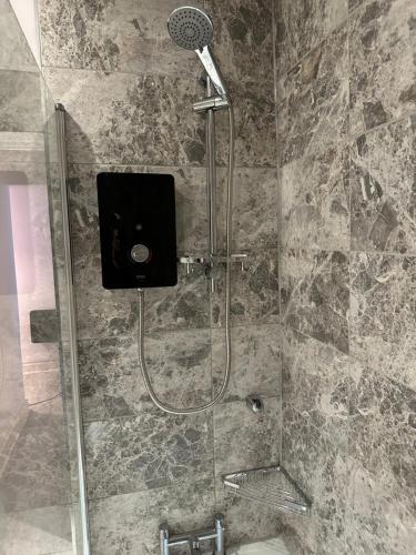 a shower with a microphone in a bathroom at Newly refurbished - Near seafront - Retro games machine - Central Brighton - 1 bedroom apartment in Brighton & Hove