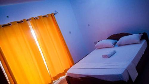 a bed in a room with an orange curtain at Three Bedroom at Nyali in Mombasa