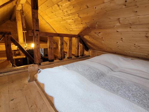 a bed in a room with a wooden ceiling at Domki drewniane pod Karpaczem 9 osobowy in Mysłakowice