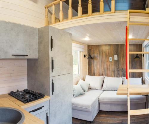 una sala de estar con un sofá blanco en una casa pequeña en Tiny House Flexhome, en Buchenberg