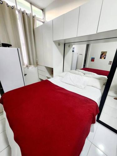 a bedroom with a red and white bed with a mirror at Lindo, fofo e aconchegante in Rio de Janeiro