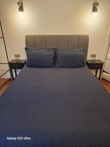 a large bed with blue pillows in a bedroom at 2 Bed Cottage, Houghton on the Hill, Leicestershire in Houghton on the Hill
