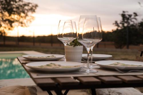 einen Tisch mit zwei Weingläsern und Tellern darauf in der Unterkunft Mas Fidel Turisme in Llambillas