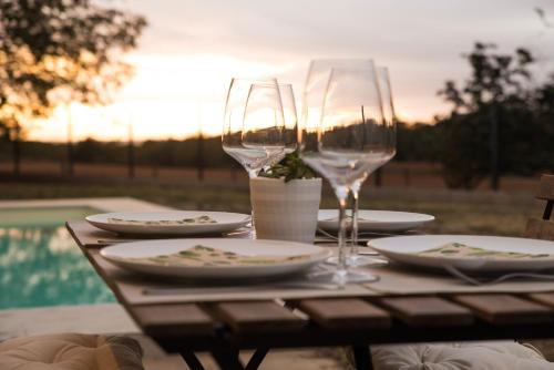 una mesa con dos copas de vino y platos en ella en Mas Fidel Turisme, en Llambillas