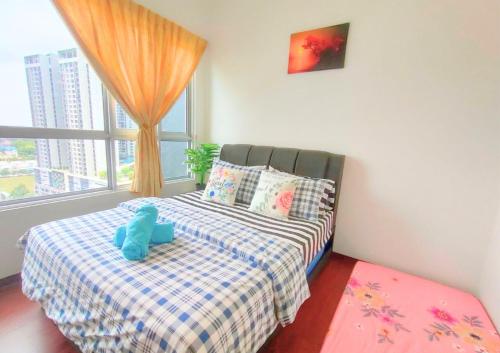 ein Schlafzimmer mit einem Bett mit einem blau ausgestopften Tier darauf in der Unterkunft Cozy Ensuite, 1-4 Pax - GA6 in Shah Alam