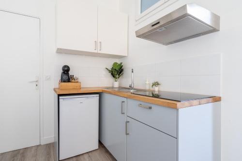 une cuisine avec des armoires blanches et un évier dans l'établissement Le César Cinéma 10 mn Paris Gare de Lyon et 5 minutes RER, à Alfortville