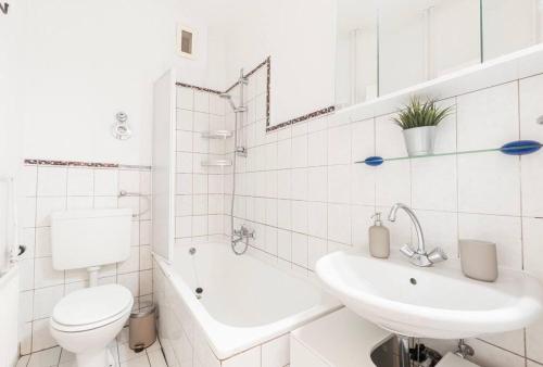 a white bathroom with a toilet and a sink at Moderne 2-Zimmer Wohnung Bremen in Bremen