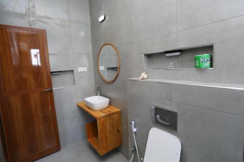 a bathroom with a sink and a toilet and a mirror at IMARA VILLA 