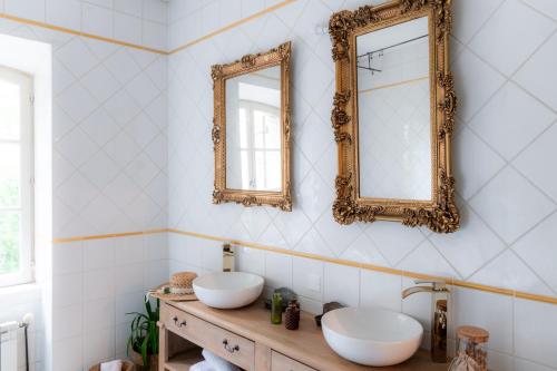 La salle de bains est pourvue de 2 lavabos et de miroirs sur le mur. dans l'établissement Chambre d'hôtes insolite lit rond B&B proche Avignon Orange - Château de Sienne Piscine Rivière, à Chusclan