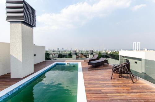 a rooftop deck with a swimming pool on a building at Modern Studio Apartment In Los Laureles in Asunción