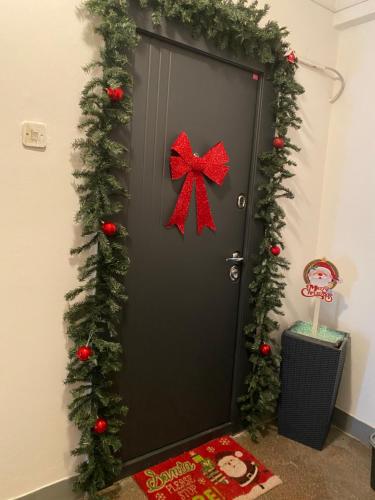 a door decorated with christmas garland and a red bow at Sweet cozy Ultracentral in Craiova