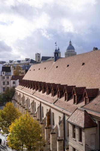 an old building with a brown roof in a city at Hôtel Pilgrim in Paris