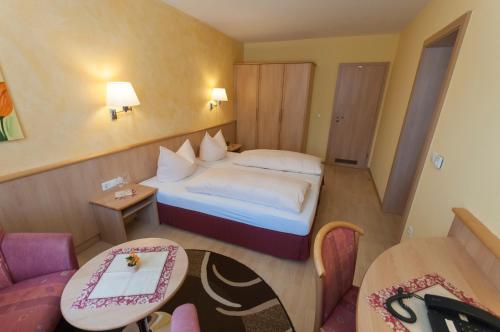 een kleine hotelkamer met een bed en een tafel bij Schreieck Maikammer Gästehaus in Maikammer