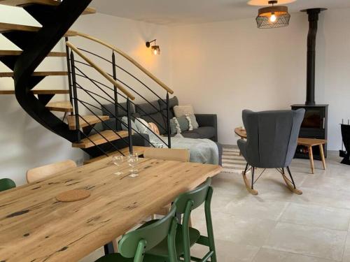 - un salon avec une table en bois et un escalier dans l'établissement Penty de La Pointe du Raz, à Plogoff