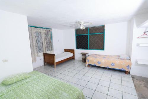 a bedroom with two beds and a couch and a window at Itapoa Reserve in Puerto Quito