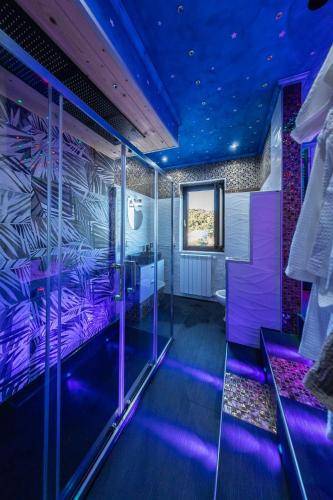 a room with a bed with purple lights in it at Norman Tower Spa in Casalbore